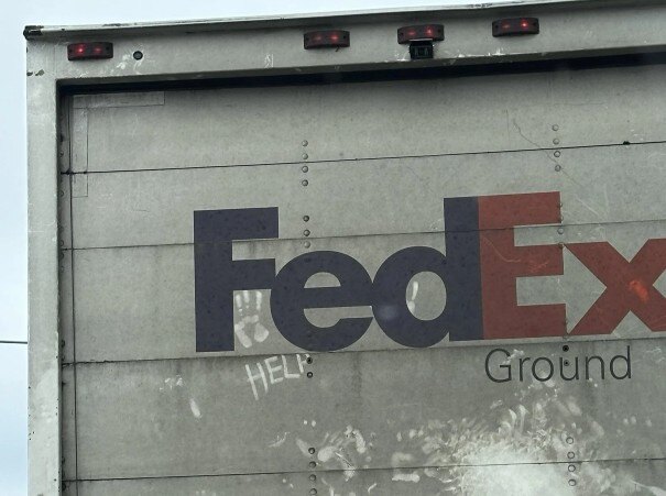 fedex-trailer-help-written-in-dirt-on-door